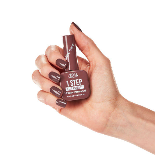 Hand holding Ardell Coffee Bean Gel Polish showing mocha brown manicure with glossy shine.