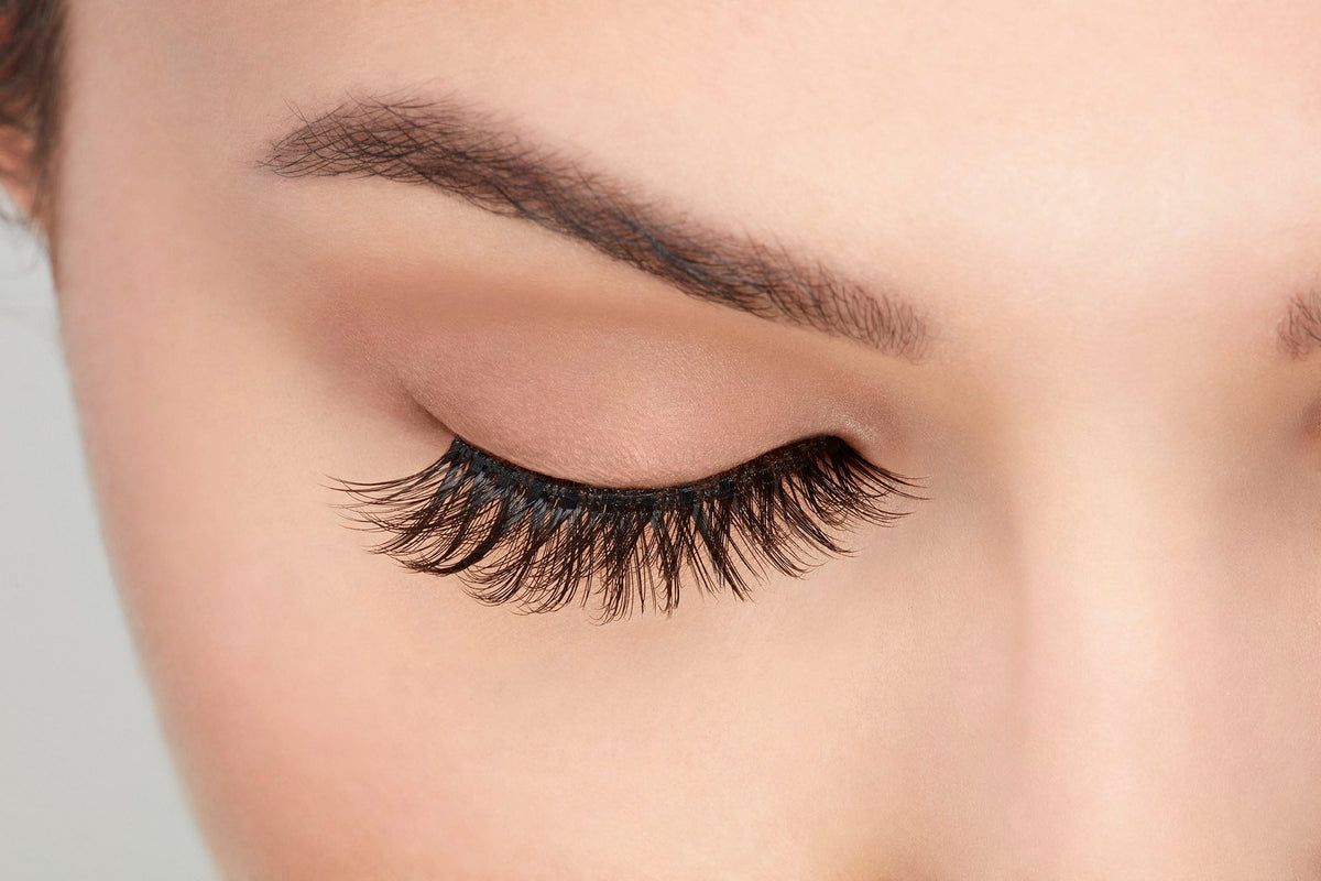 Close-up of Ardell natural lashes on closed eye, highlighting soft volume and realistic lash tapering.
