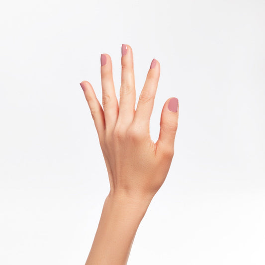 A woman hand with a nail cuticle in Wild Orchid color shade