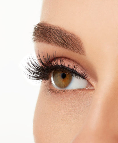 An extreme side close up shot of a model's eye wearing Ardell Double Up 207 creating natural, flared eyelash