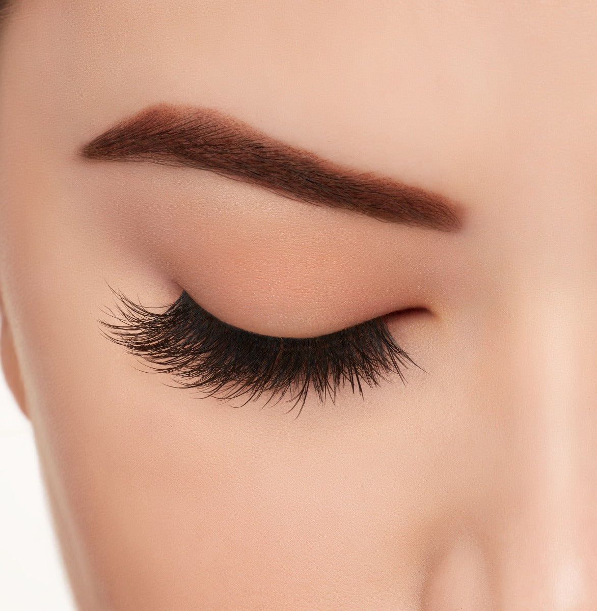 A model's closed right eye wearing Ardell Mega Volume 262 faux lashes