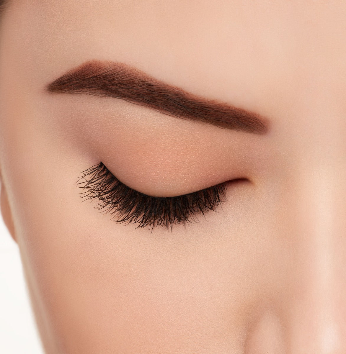 A model wearing Ardell Eco Lashes 451 upper false lashes in close eye emphasizing the curly, flared & natural lash look