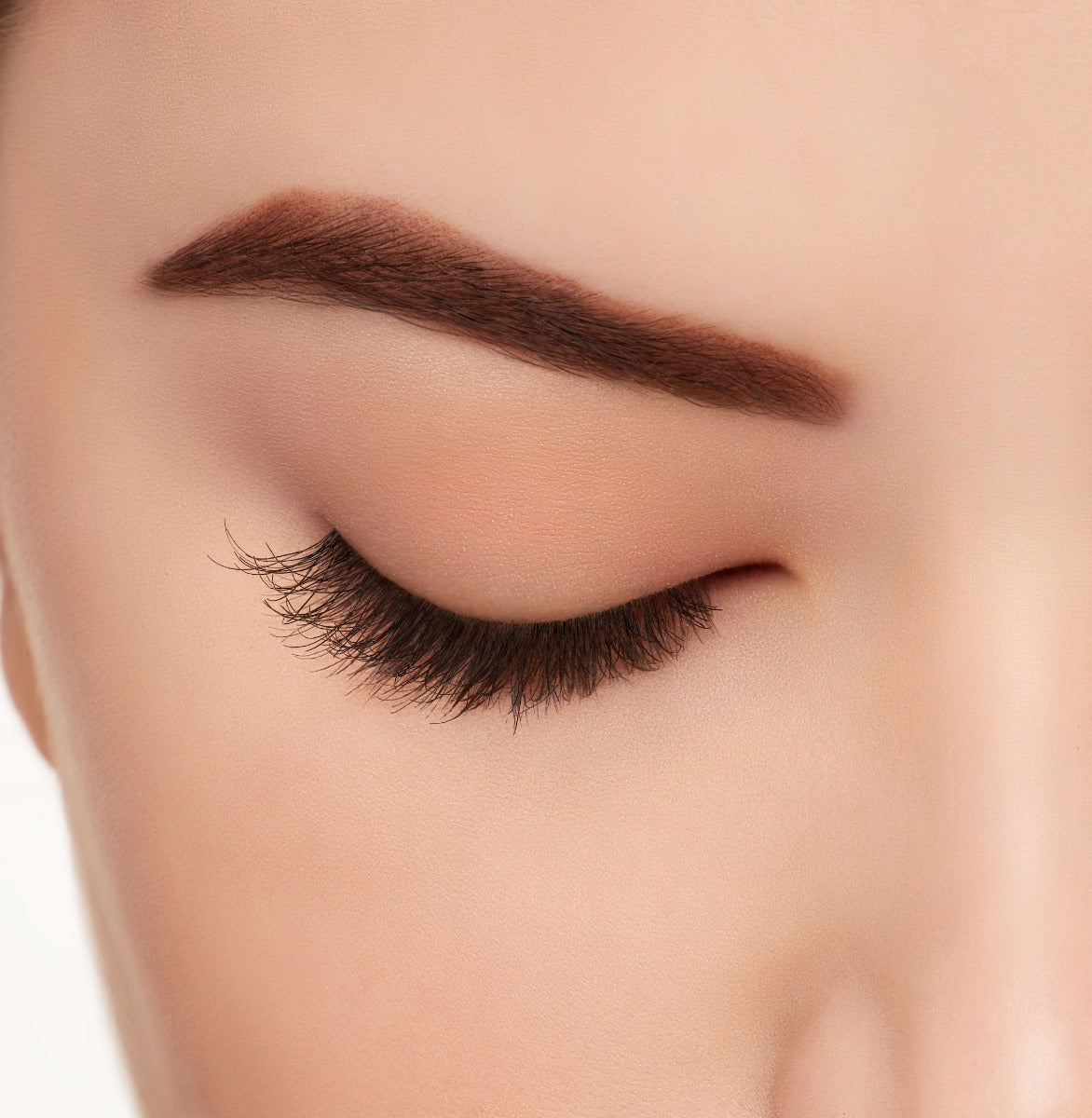A model wearing Ardell's Ecolashes 454 with close right eye showing its extra-long layers with intense volume & fullness lash