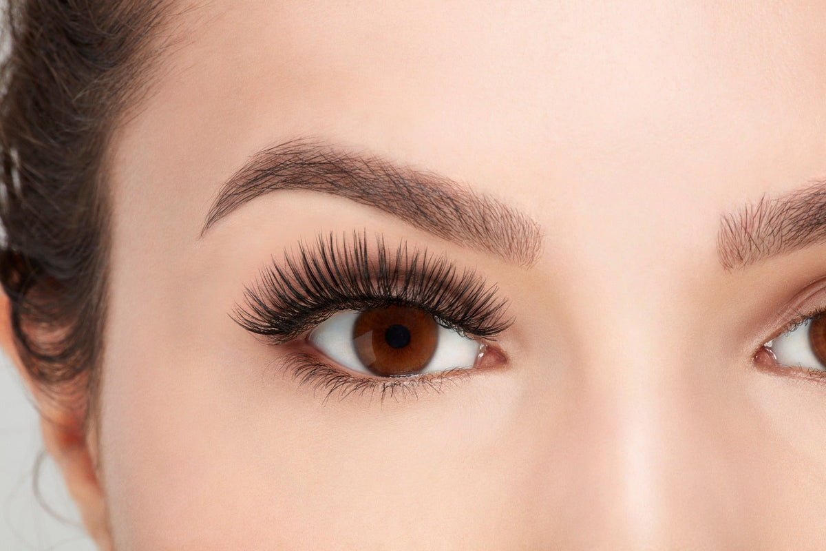 A model wearing Ardell's Faux mink 817 with open right eye showing its flared, winged-out & natural lash look