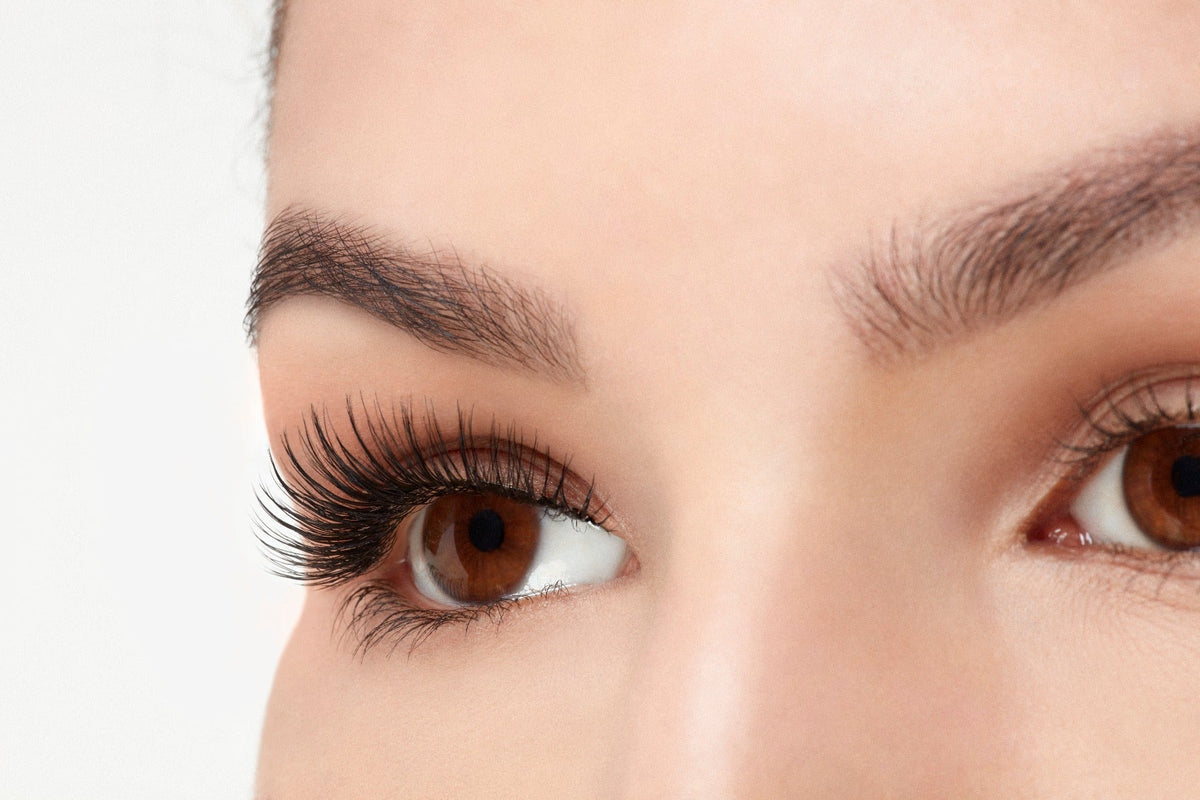 A model wearing Ardell's Faux mink 817 with open right eye in side view, showing winged-out & natural lash look
