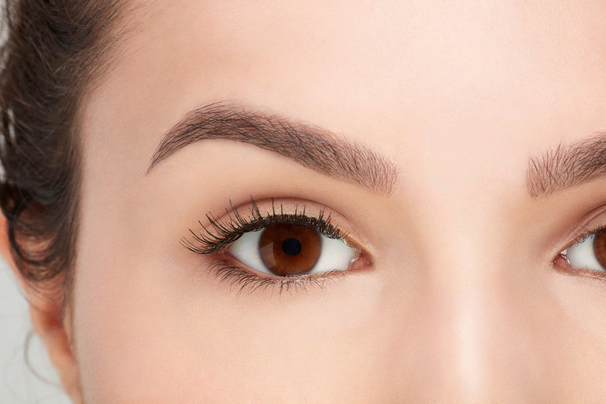 A model with an open right eye wearing Ardell Natural 110 showing its rounded lash style & staggered length