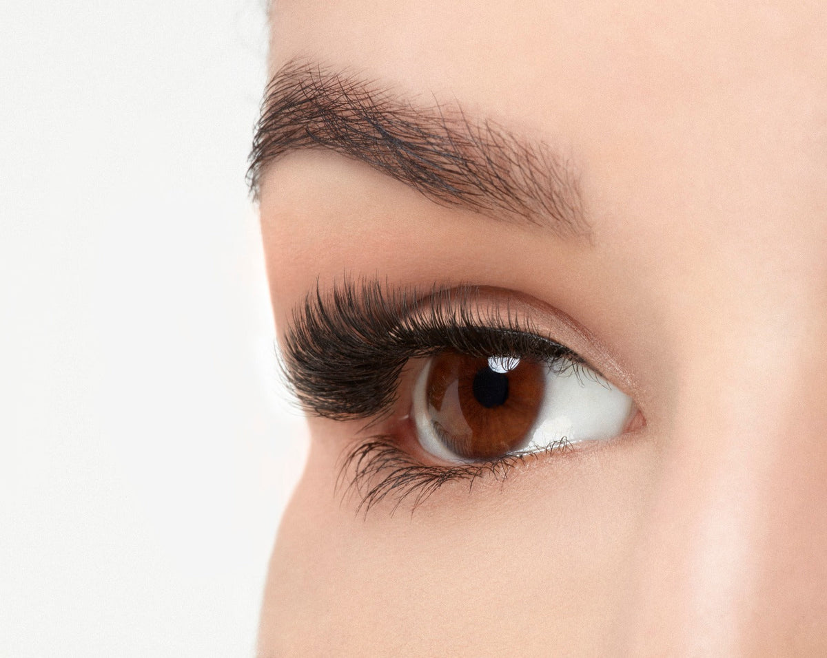 An extreme side close up shot of an eye wearing a Fauxmink 815 by Ardell creating a wide, full & natural eyelash look