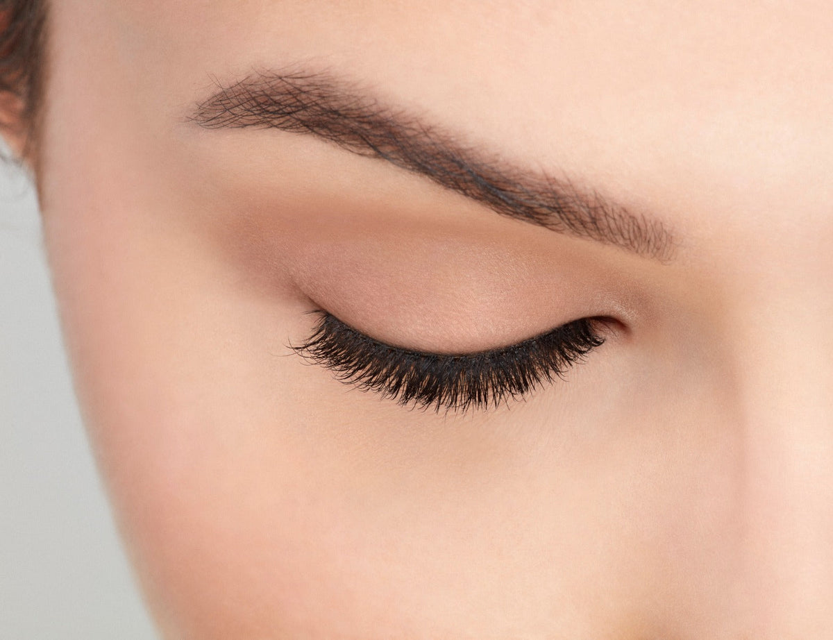 Model with closed right eye wearing Ardell Pre-Cut Lashes 900 showing how it looks flared & natural on the eye