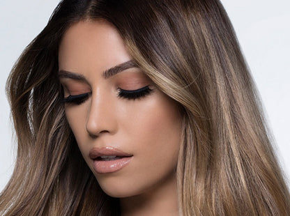A model with long, voluminous false eyelashes applied using DUO lash adhesive, showcasing a dramatic eye look.